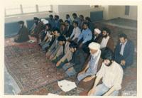 امام هنگام نماز جماعت در قم در حالت تشهد به صورت نیم رخ