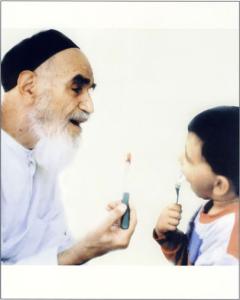 امام به همراه نوه خود در حال خوردن هندوانه در جماران